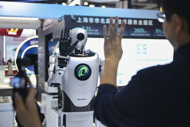 A visitor interacts with a humanoid robot at the exhibition area of the 2025 World Artificial Intelligence Conference and High-Level Meeting on Global AI Governance in Shanghai, July 26, 2025. 
